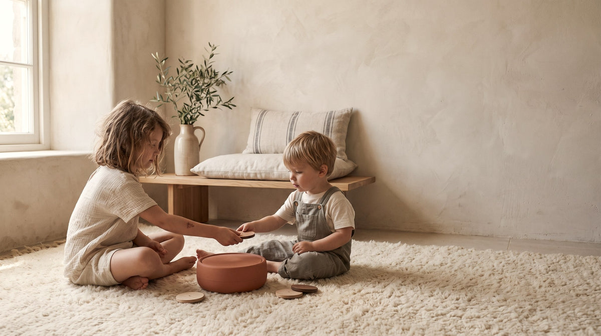 Two children listening to the Tondo together on a rug, with no screens in the room